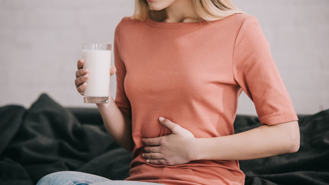 holding glass of milk while sitting on sofa